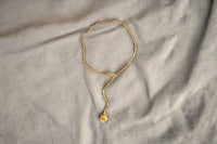 a gold necklace with a pendant on it