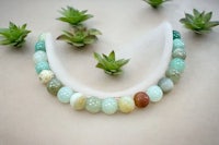 a necklace with green, yellow, and brown beads