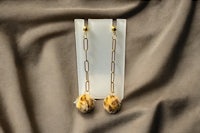a pair of gold plated earrings with a brown stone
