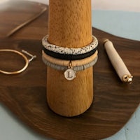 a stack of bracelets on a wooden tray