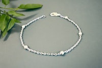 a silver bracelet with a leaf on it