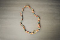 a colorful braided necklace on a table